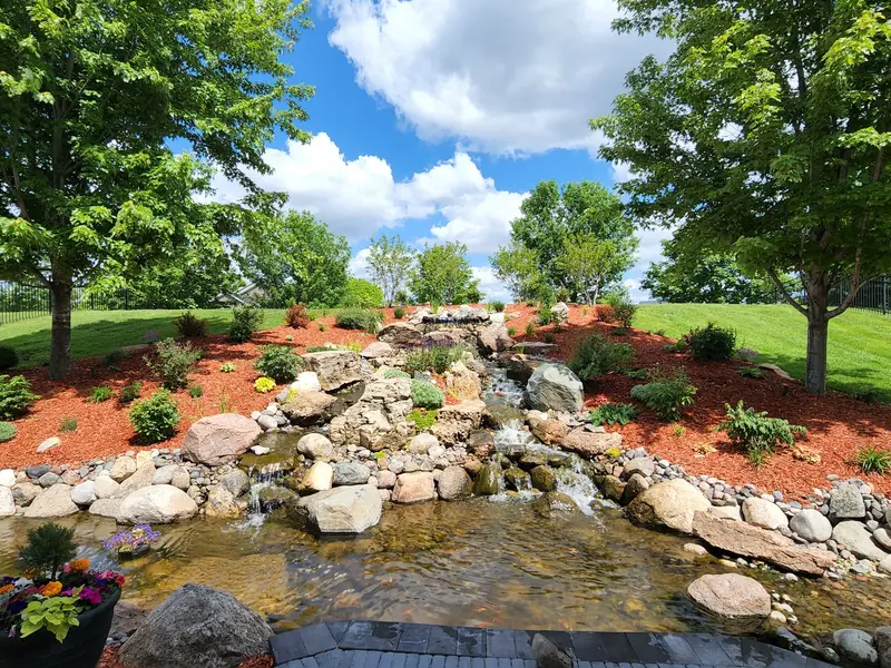 A backyard waterfall and stream garden with koi built by Green Dynamics